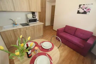 a living room with a table and a purple couch at Apartments Sobieski&Soplica in Kraków