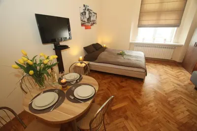 a living room with a table and a couch at Apartments Sobieski&Soplica in Kraków