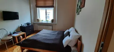 a small bedroom with a bed and a window at Apartments Sobieski&Soplica in Kraków
