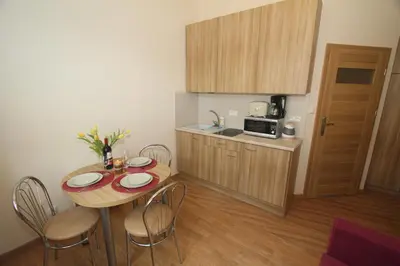 a small kitchen with a table and chairs in a room at Apartments Sobieski&Soplica in Kraków