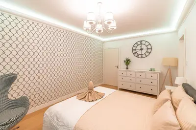a bedroom with a bed and a clock on the wall at Heart of Kraków Comfort Apartments by Rentujemy in Kraków