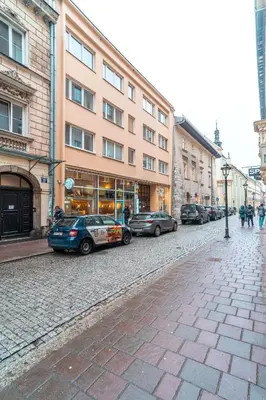 a street with cars parked in front of buildings at Heart of Kraków Comfort Apartments by Rentujemy in Kraków