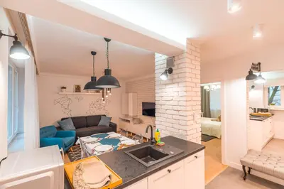 a kitchen and living room with a couch and a table at Heart of Kraków Comfort Apartments by Rentujemy in Kraków