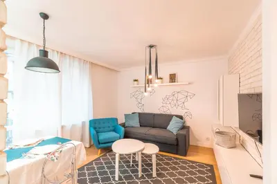a living room with a couch and a chair at Heart of Kraków Comfort Apartments by Rentujemy in Kraków