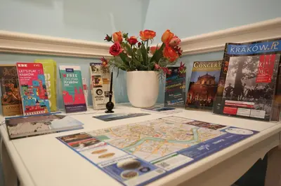 a table with books and a vase with flowers at Blueberry Apartments in Kraków