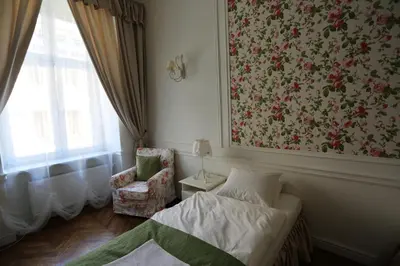 a bedroom with a bed and a chair next to a window at Blueberry Apartments in Kraków