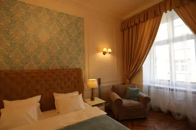 a bedroom with a bed and a chair and a window at Blueberry Apartments in Kraków