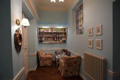 a hallway with a table and two chairs and a book shelf at Blueberry Apartments in Kraków