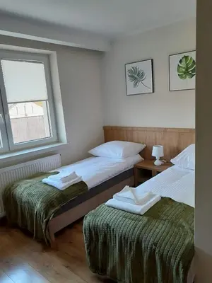 a bedroom with two beds and a window at Folwark Bielanka in Bielanka