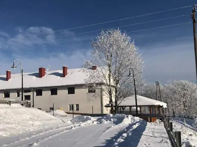 a snow covered building with a snow covered roof at Folwark Bielanka in Bielanka