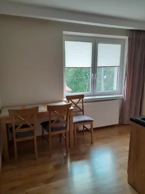 a dining room with a table and chairs and windows at Folwark Bielanka in Bielanka