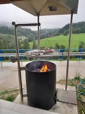 a fire pit under an umbrella with a view at Folwark Bielanka in Bielanka