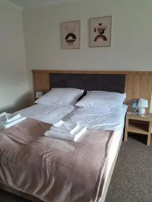 a bed with two white towels on top of it at Folwark Bielanka in Bielanka