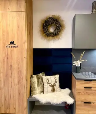 a room with a bench with a wreath on the wall at OVIS HOMES APP in Zawoja