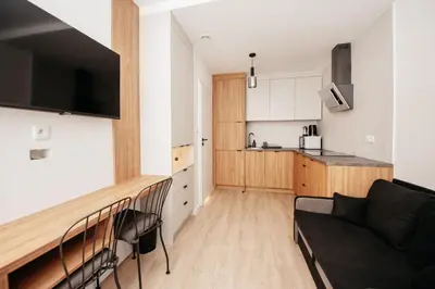 a living room with a couch and a kitchen at Cozy Studio for couples - Cracow city heart in Kraków