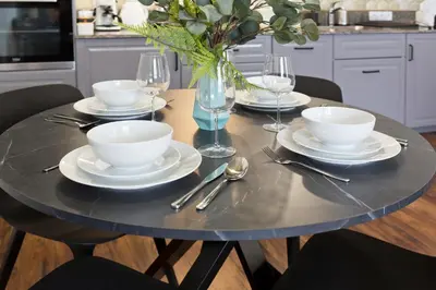 a table with plates and silverware on top of it at Charming 2-Room Apartment Near Wawel Castle in Kraków