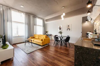 a living room with a yellow couch and a table at Charming 2-Room Apartment Near Wawel Castle in Kraków