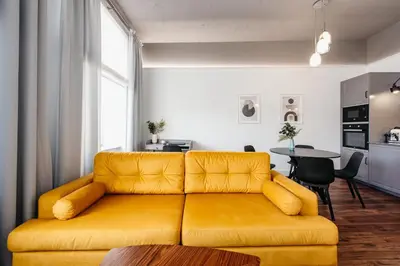 a living room with a yellow couch and a table at Charming 2-Room Apartment Near Wawel Castle in Kraków