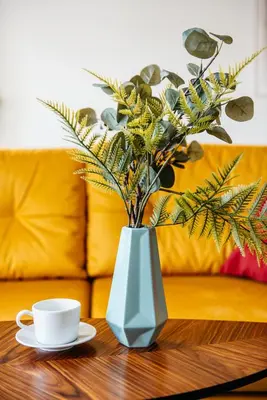 a table with a vase with a cup and a coffee mug at Charming 2-Room Apartment Near Wawel Castle in Kraków