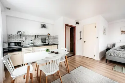 a kitchen and living room with a table and chairs at Fully-furnished Apartment with Air Conditioning for families, Cracow Old Town in Kraków