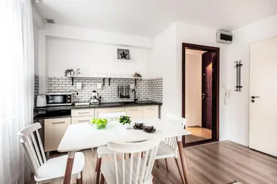 a white kitchen with a white table and chairs at Fully-furnished Apartment with Air Conditioning for families, Cracow Old Town in Kraków