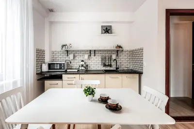 a white kitchen with a white table and chairs at Fully-furnished Apartment with Air Conditioning for families, Cracow Old Town in Kraków