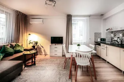a kitchen and living room with a table and chairs at Fully-furnished Apartment with Air Conditioning for families, Cracow Old Town in Kraków