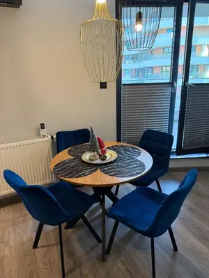 a dining room table with blue chairs and a plate on it at Beautiful Apartment- FREE GARAGE- WIŚLANE TARASY in Kraków