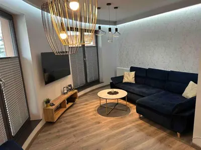 a living room with a blue couch and a table at Beautiful Apartment- FREE GARAGE- WIŚLANE TARASY in Kraków
