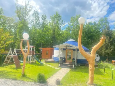 a playground with a gazebo and two wooden trees at Slow Flow Glamp in Rzyki