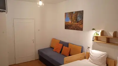 a living room with a blue couch with orange pillows at Królówka in Maków Podhalański