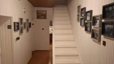 a staircase in a hallway with pictures on the walls at Królówka in Maków Podhalański