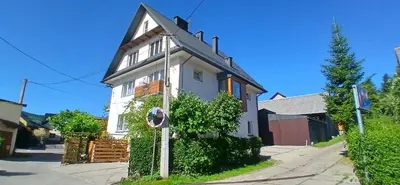 a white house with a sign in front of it at Królówka in Maków Podhalański