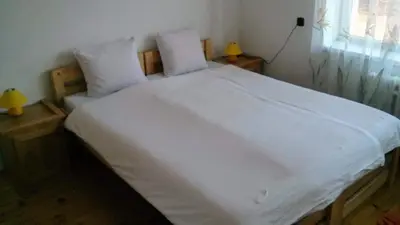 a large white bed with two pillows and a window at Królówka in Maków Podhalański