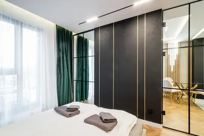 a bedroom with a bed and a glass wall at Greendustry Zabłocie Luxury Apartments WAWELOFTS in Kraków