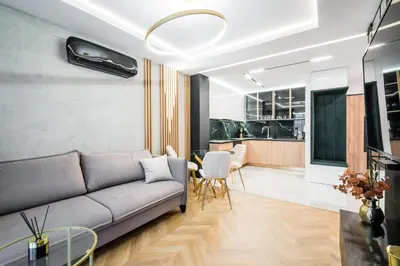 a living room with a couch and a table at Greendustry Zabłocie Luxury Apartments WAWELOFTS in Kraków