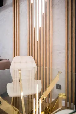 a glass table with a white chair in a room at Greendustry Zabłocie Luxury Apartments WAWELOFTS in Kraków
