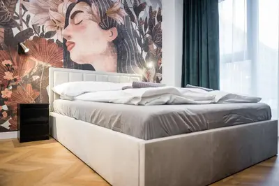 a bed in a room with a painting on the wall at Greendustry Zabłocie Luxury Apartments WAWELOFTS in Kraków