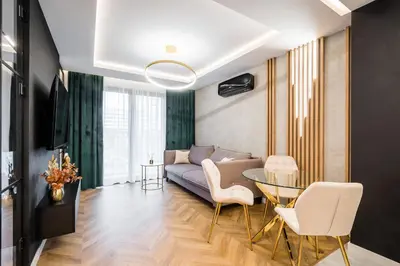 a living room with a couch and a glass table at Greendustry Zabłocie Luxury Apartments WAWELOFTS in Kraków