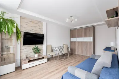 a living room with a blue couch and a tv at Park Białoprądnicki Blue Studio by BookingHost in Kraków