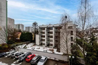 a parking lot with cars parked in front of a building at Park Białoprądnicki Blue Studio by BookingHost in Kraków