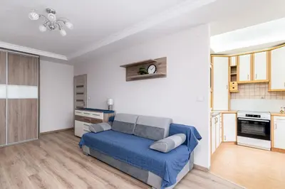 a living room with a bed and a kitchen at Park Białoprądnicki Blue Studio by BookingHost in Kraków