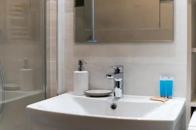 a white sink in a bathroom with a shower at Park Białoprądnicki Blue Studio by BookingHost in Kraków