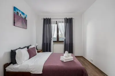a bedroom with a large bed and a window at Lea Cosy Apartment by BookingHost in Kraków