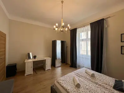 a bedroom with a bed and a large window at Apartament rodzinny 14 in Kraków