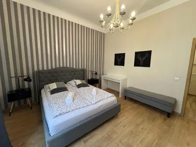a bedroom with a bed and a chandelier at Apartament rodzinny 14 in Kraków