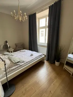 a bedroom with a bed and a window at Apartament rodzinny 14 in Kraków
