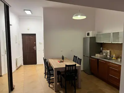 a kitchen and dining room with a table and chairs at Apartament rodzinny 14 in Kraków