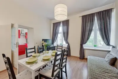 a dining room with a white table and chairs at Apartament rodzinny 14 in Kraków