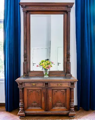 a wooden dresser with a mirror and a vase of flowers at Center High Apartment CityBeat#1 in Kraków